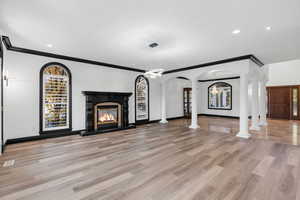 Unfurnished living room with crown molding, light hardwood / wood-style floors, and an inviting chandelier