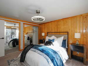 Bedroom featuring wood walls and carpet floors