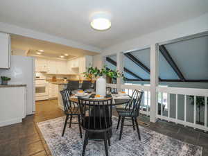 Dining space with vaulted ceiling with beams