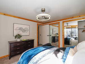 Bedroom featuring light colored carpet and two closets