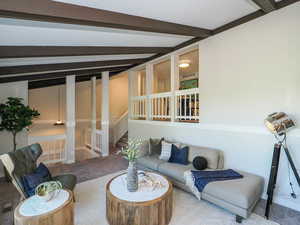 Carpeted living room with beam ceiling