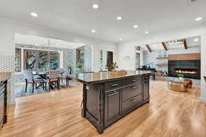 Kitchen featuring a center island, a tiled fireplace, dark stone counters, and french doors