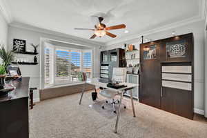 Carpeted office featuring a textured ceiling, ceiling fan, and ornamental molding