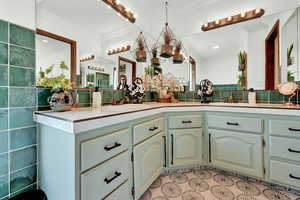 Bathroom with ornamental molding, vanity, and tile patterned flooring