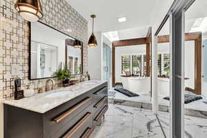 Bathroom featuring vanity, shower with separate bathtub, and tasteful backsplash