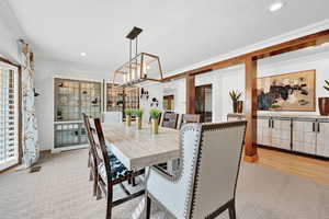 Dining space featuring crown molding, light hardwood / wood-style flooring, and a notable chandelier