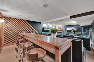 Interior space featuring carpet floors, a textured ceiling, and a stone fireplace