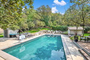 View of pool featuring an outdoor structure and a patio