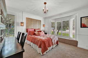 Bedroom featuring ornamental molding, a textured ceiling, a chandelier, and carpet flooring