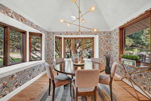 Sunroom with lofted ceiling and a notable chandelier