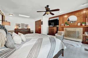 Bedroom featuring wood walls, carpet flooring, crown molding, and ceiling fan