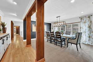 Carpeted dining area featuring a textured ceiling and ornamental molding