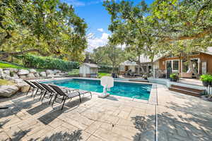 View of pool featuring a shed and a patio