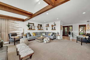 Carpeted living room with crown molding and beam ceiling