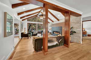 Living room featuring light wood-type flooring and lofted ceiling with beams