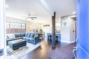 Living room with dark wood-type flooring and ceiling fan