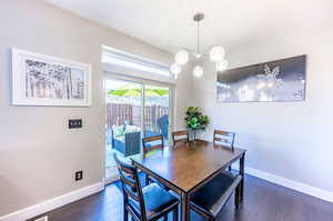 Dining space with dark hardwood / wood-style flooring and a notable chandelier