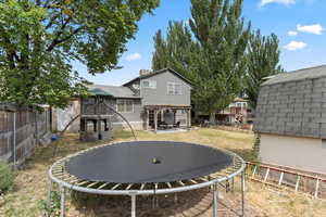 View of yard featuring a trampoline and a pergola