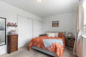 Carpeted bedroom featuring two closets