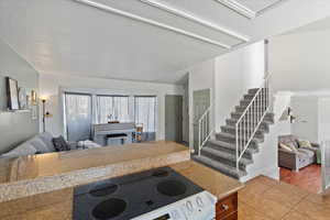 Kitchen featuringtile floors, light stone countertops, and white electric range oven