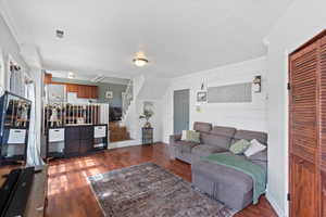 Living room with dark hardwood / wood-style flooring and ornamental molding