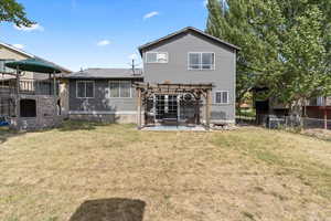 Back of house with a lawn, a patio, and a pergola