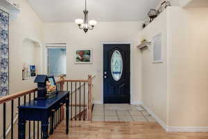 Foyer featuring hardwood / wood-style flooring and a notable chandelier