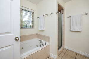 Bathroom featuring separate shower and tub and tile patterned floors