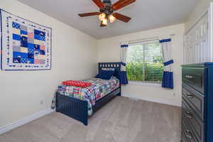 Carpeted bedroom with ceiling fan