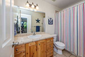 Bathroom with vanity, toilet, and tile patterned floors