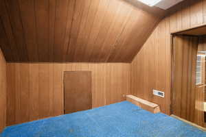 Bonus room featuring lofted ceiling, carpet floors, wooden walls, and wooden ceiling