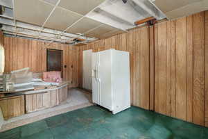 Previous hot-tub room featuring wooden walls and white fridge