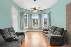 Living room featuring ceiling fan and light hardwood / wood-style floors