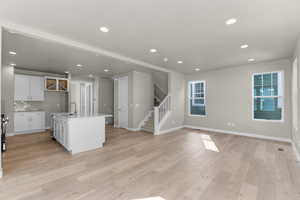 Kitchen with an island with sink, a wealth of natural light, sink, and light hardwood / wood-style floors