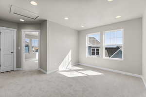 Empty room with light colored carpet and a wealth of natural light