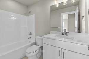 Full bathroom featuring vanity, toilet, tile patterned floors, and  shower combination