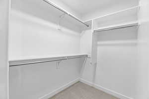 Spacious closet with light colored carpet