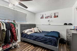 Bedroom with ceiling fan, dark hardwood / wood-style flooring, and a textured ceiling