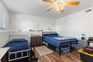 Bedroom featuring ornamental molding, dark hardwood / wood-style flooring, and ceiling fan