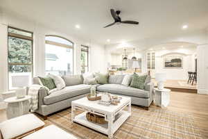 Living room with light wood-type flooring, ceiling fan, and crown molding