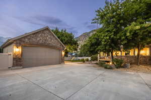 Property exterior at dusk featuring a mountain view, an outdoor structure, and a garage