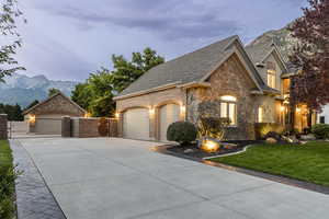 French country inspired facade featuring a mountain view, a front yard, and a garage