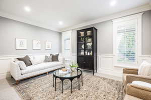 Living room featuring crown molding and carpet flooring