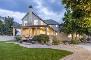 Back of property featuring a yard and a porch