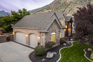 View of front of home featuring a mountain view, a garage, and a lawn