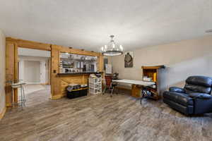 Living room featuring hardwood / wood-style floors, a chandelier, and a textured ceiling