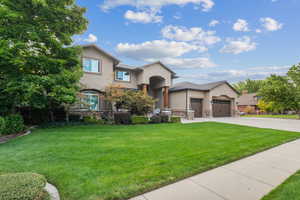 View of front of property with a front yard and a garage