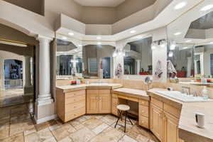 Primary Bathroom featuring a towering ceiling, vanity, and decorative columns