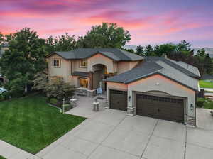 View of front of house with a yard and a garage