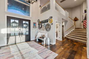 Foyer entrance with a towering ceiling, french doors, and dark hardwood / wood-style floors